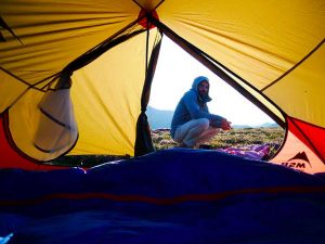 Homme regardant l'intérieur d'une tente sur un bivouac