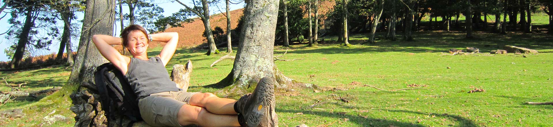 Femme relax allongée sur un tronc d'arbre pendant une randonnée avec Bivouac